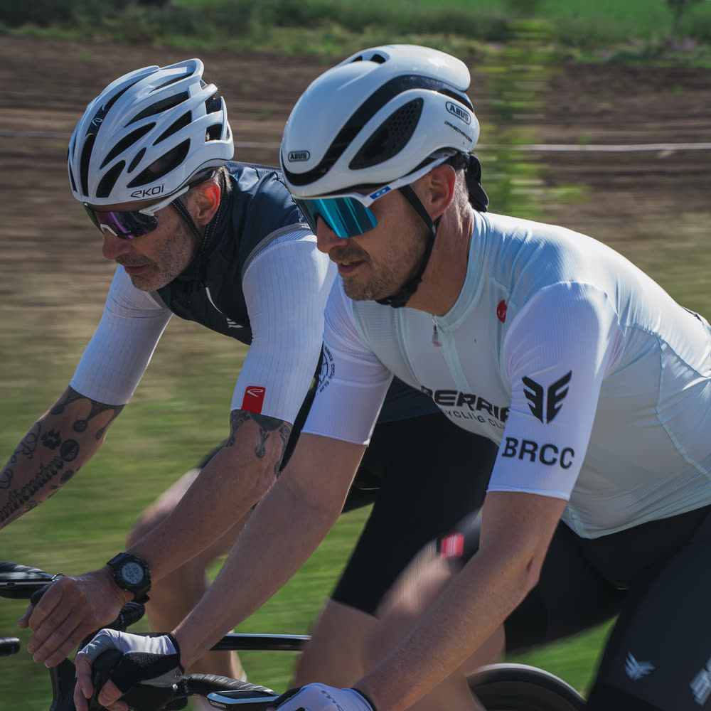 Dos ciclistas rodando juntos con el maillot Berria Cycling Club